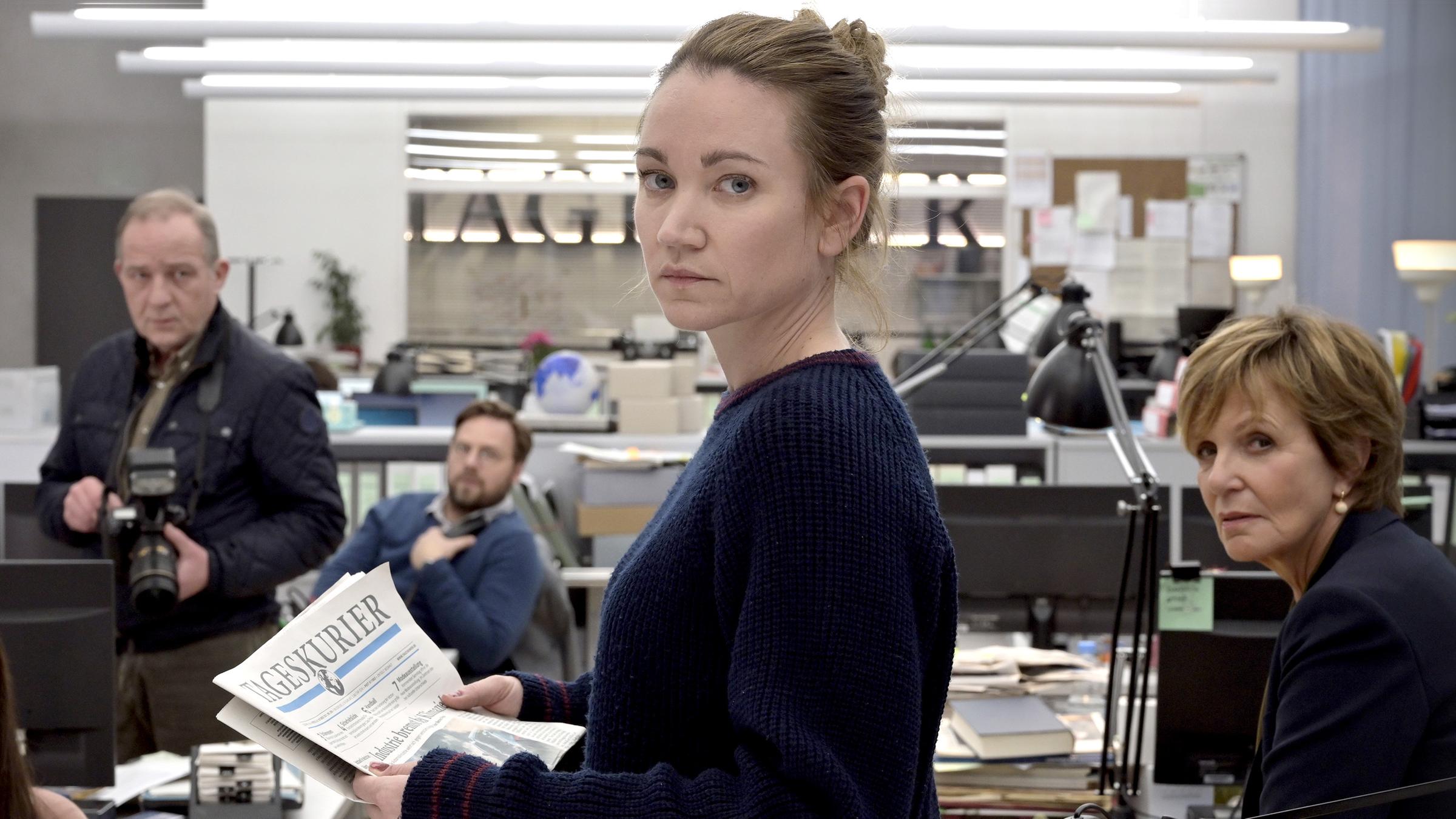 "Gefährliche Wahrheit": Blick in die Redaktionsräume des Tageskuriers. Die Mitarbeiter (Amila Bagriacik, Uwe Preuss, Christoph Letkowski, Ulrike Kriener) haben sich um ihre Kollegin Maren Gehrke (Lisa Maria Potthoff) versammelt. Sie hält eine Ausgabe der Zeitung in den Händen und blickt über die Schulter in Richtung der Kamera.