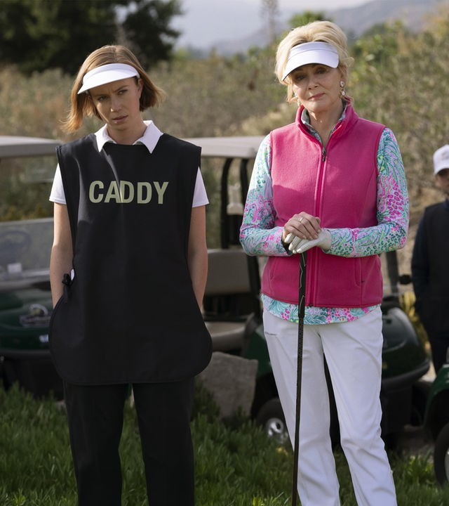 "Hacks - Fehlschläge": Deborah (Jean Smart) und Ava (Hannah Einbinder) stehen in Golfoutfits vor Golfcarts. Deborah hält einen Golfschläger in ihren Händen. Ava schaut skeptisch und hat ihre Hände in den Hosentaschen. Im Hintergrund steht eine weitere Person (Komparse) zwischen Golfcarts.