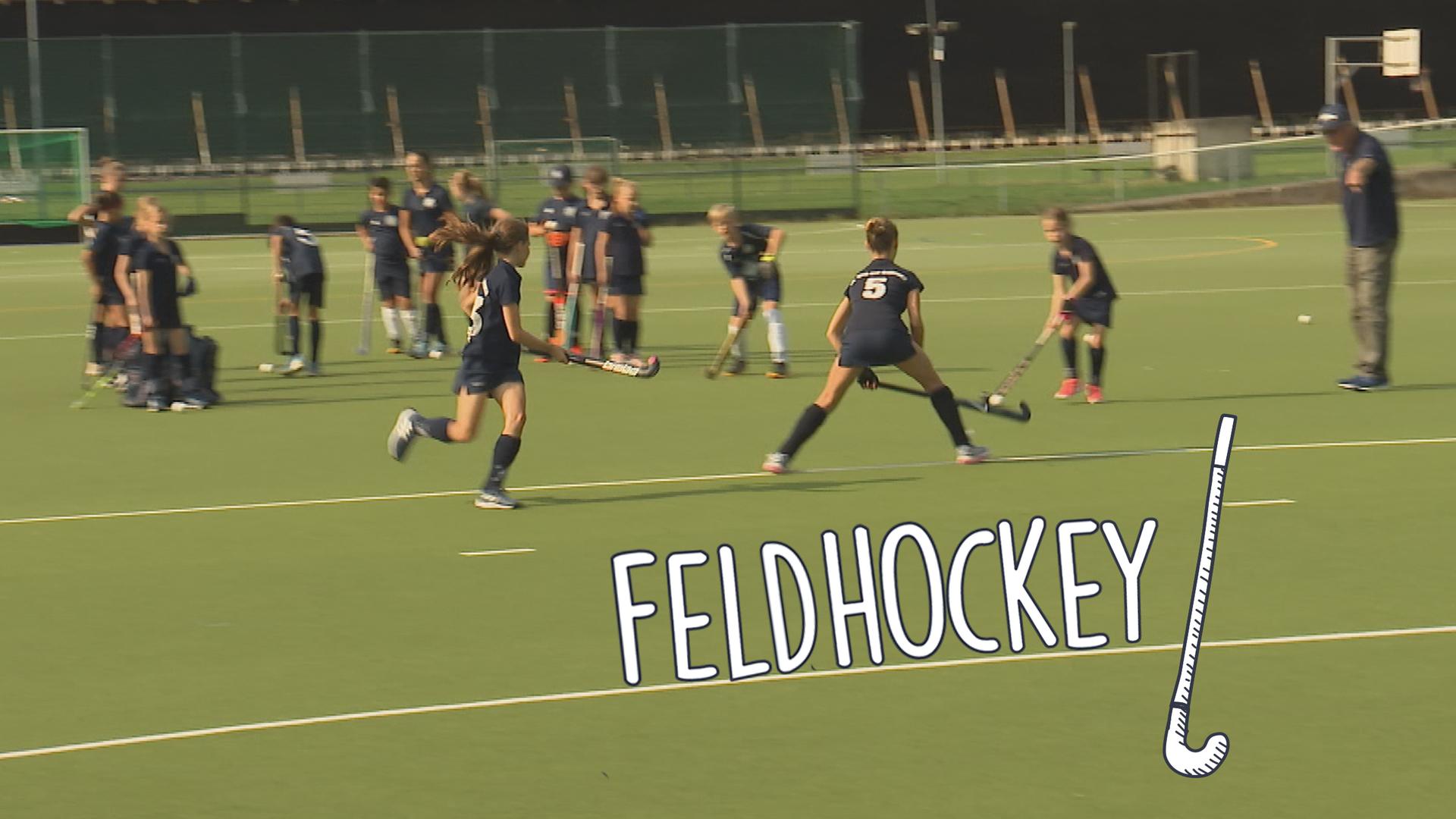 Kinder spielen Feldhockey