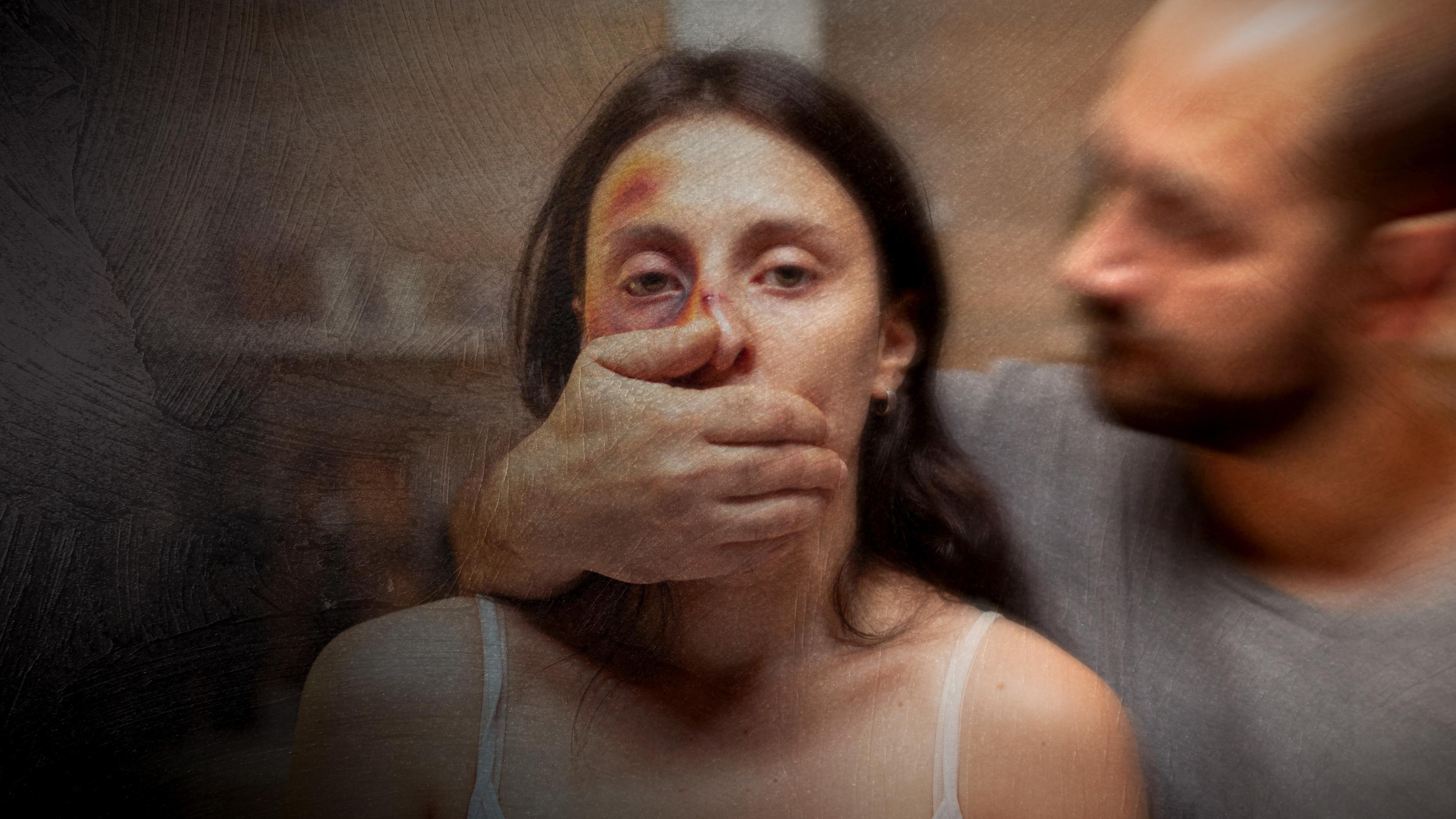 Eine Frau mit sichtbaren Verletzungen im Gesicht, ein Mann steht neben ihr und hält ihr den Mund zu.