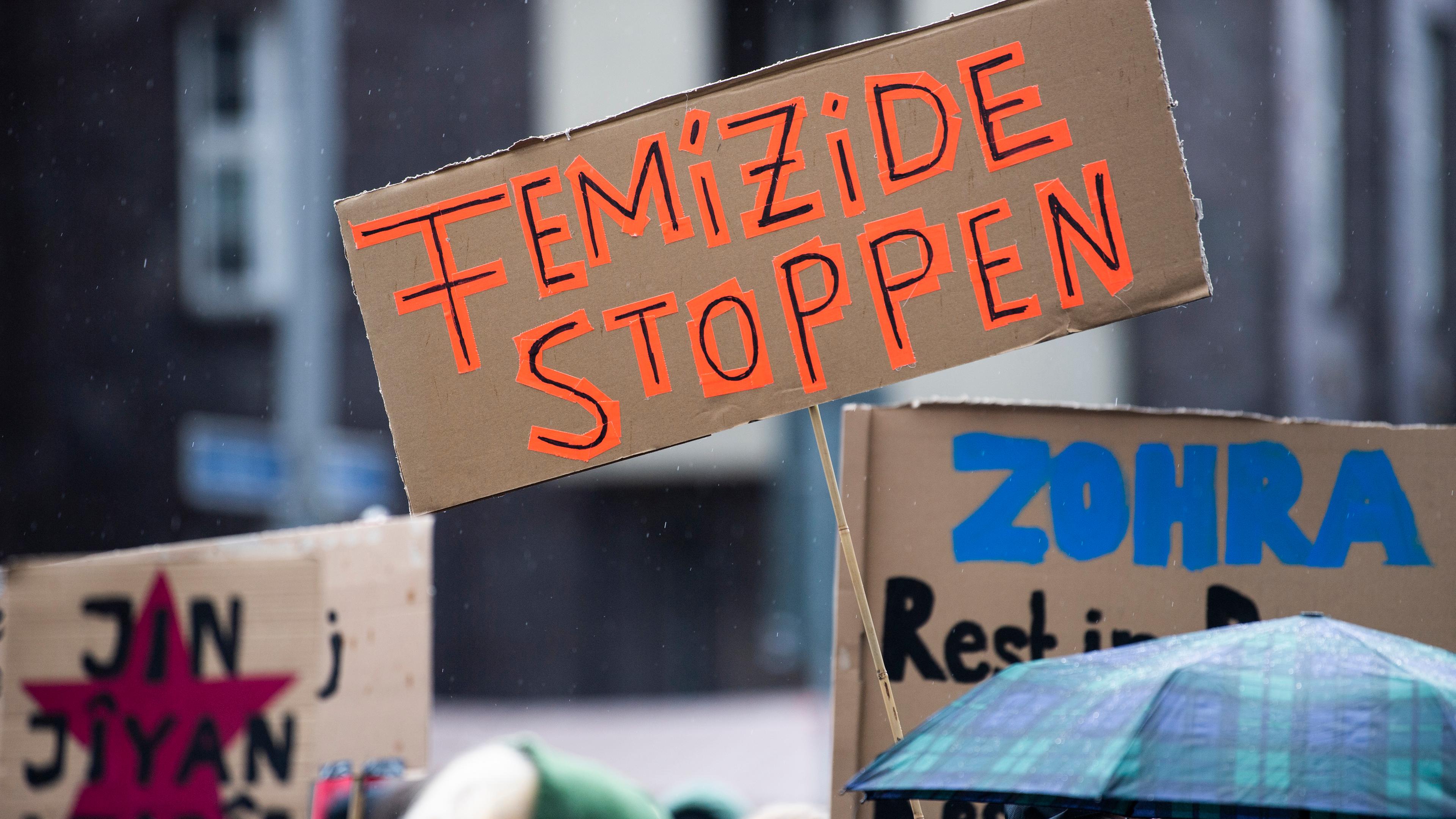 Bei einer Demonstration gegen Gewalt an Frauen hält eine Teilnehmerin ein Plakat mit der Aufschrift «Femizide stoppen»
