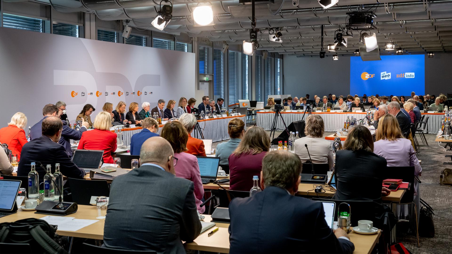 Blick in Raum zur ZDF-Fernsehratssitzung mit Mitgliedern an den Tischen während einer Sitzung