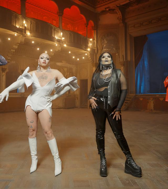 Man sieht Travestiekünstler auf einer Bühne.