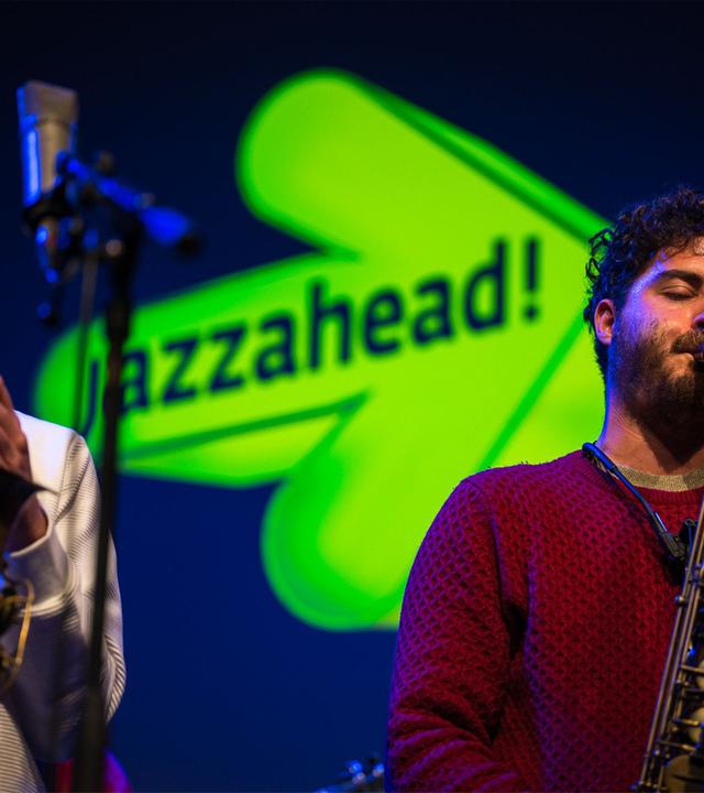 Man sieht zwei Jazzmusiker mit Saxophon auf der Bühne.