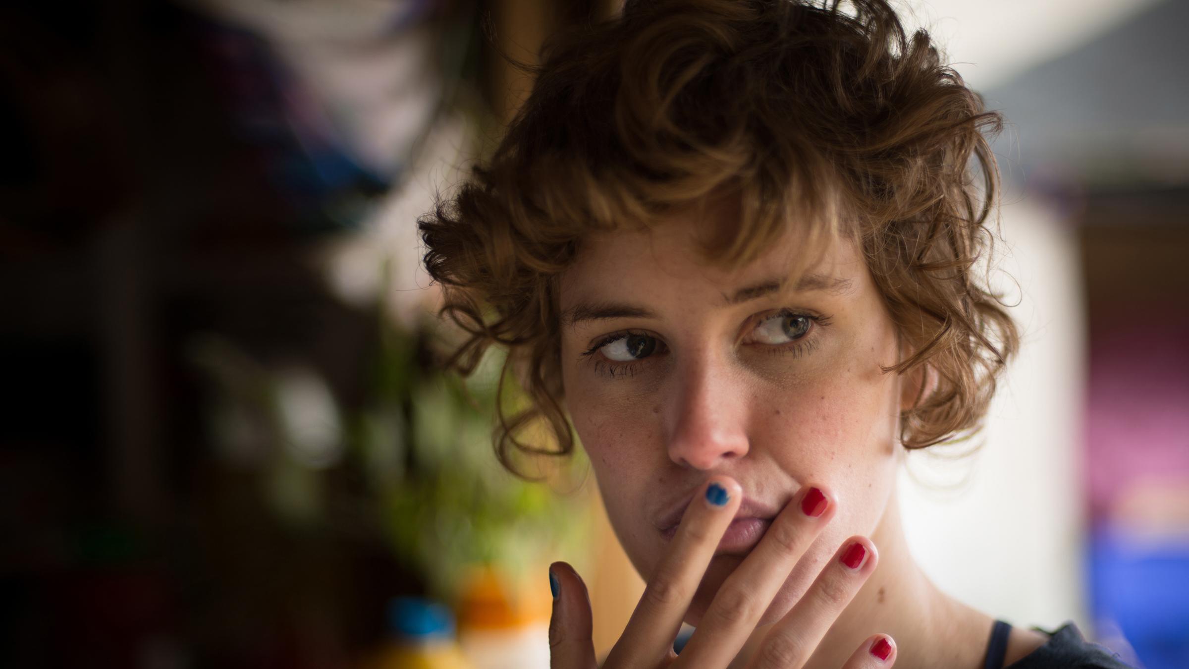 Helen (Carla Juri) in Nahaufnahme. Sie hält sich ihre Hand an den Mund.