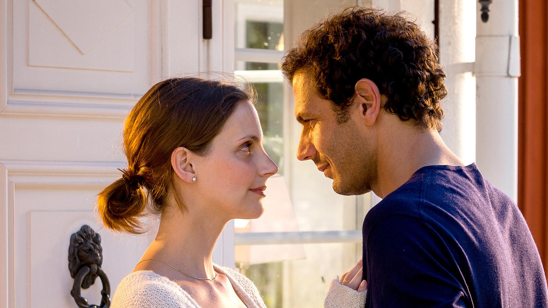 Paul (Mehdi Nebbou) und Sofia (Marie Zielcke) stehen vor einem Fenster und schauen sich tief in die Augen.