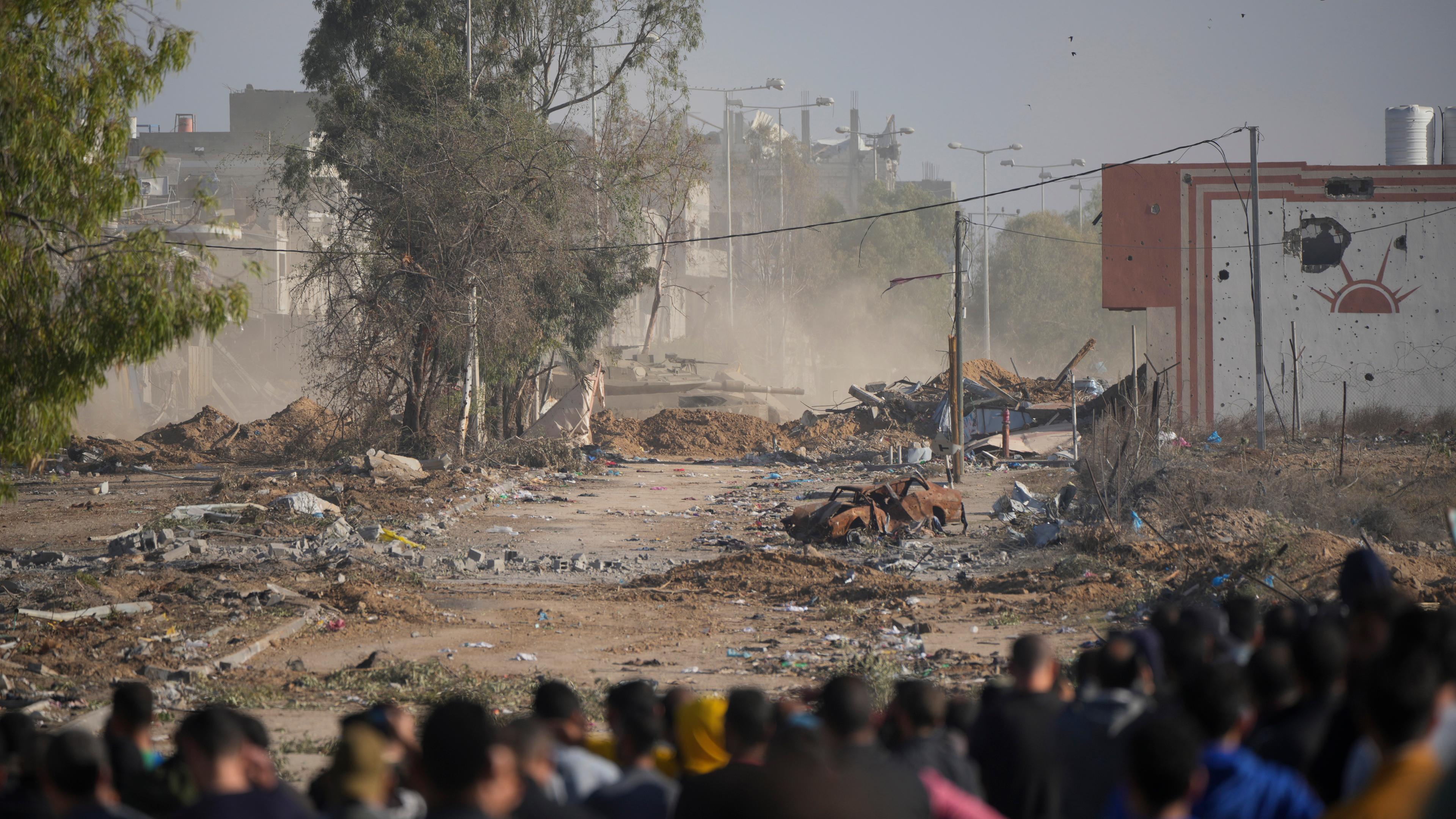 Palästinenser versuchen, in den nördlichen Gazastreifen zurückzukehren, als ein israelischer Panzer am Freitag, dem 24. November 2023, die Straße Salah al-Din im zentralen Gazastreifen blockierte, als der vorübergehende Waffenstillstand in Kraft trat.