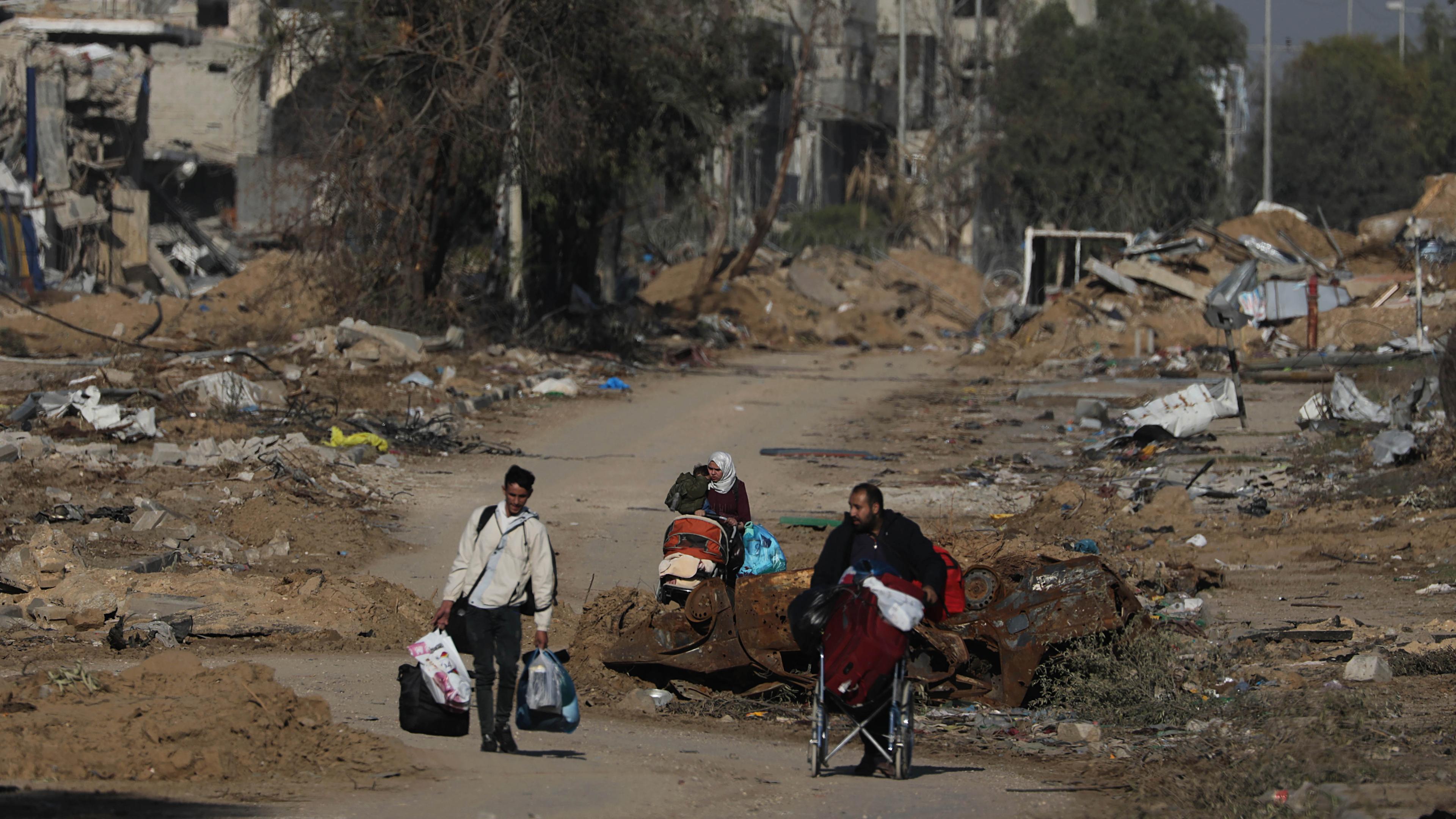 Palästinensiche Zivilisten laufen durch die Trümmer im Gazastreifen.