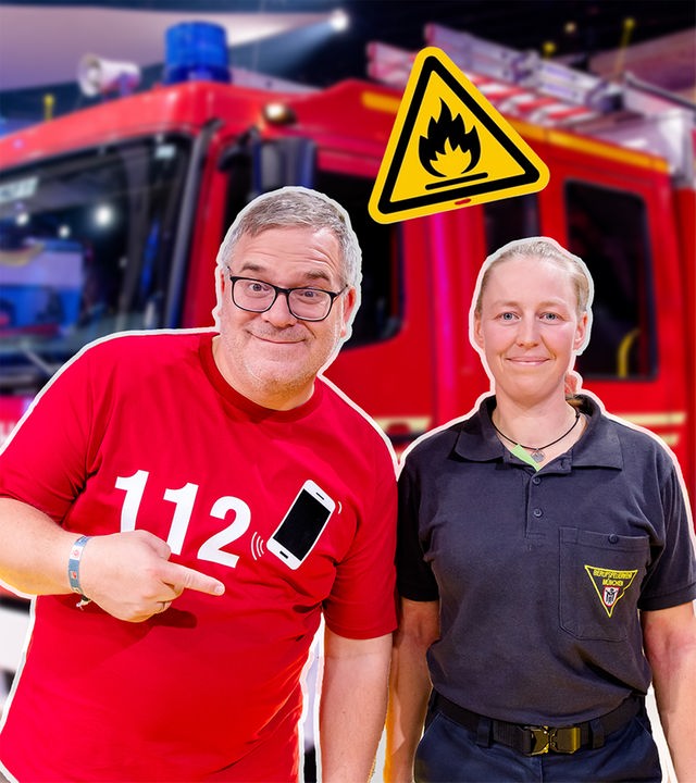 Elton steht mit einer Feuerwehrfrau vor einem Feuerwehrauto