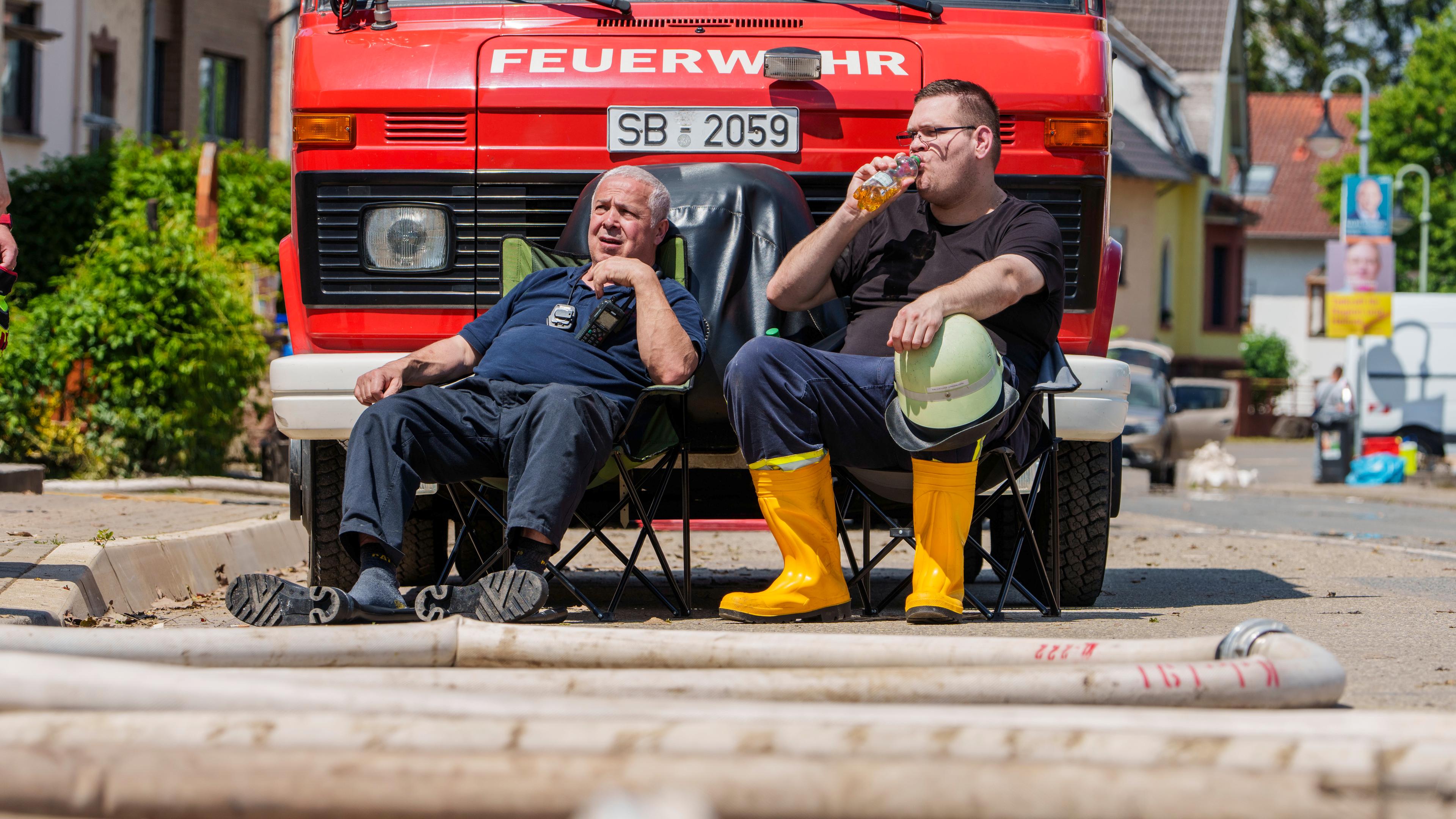 Saarland, Kleinblittersdorf: Zwei Einsatzkräfte der Freiwilligen Feuerwehr Kleinblittersdorf machen Pause.