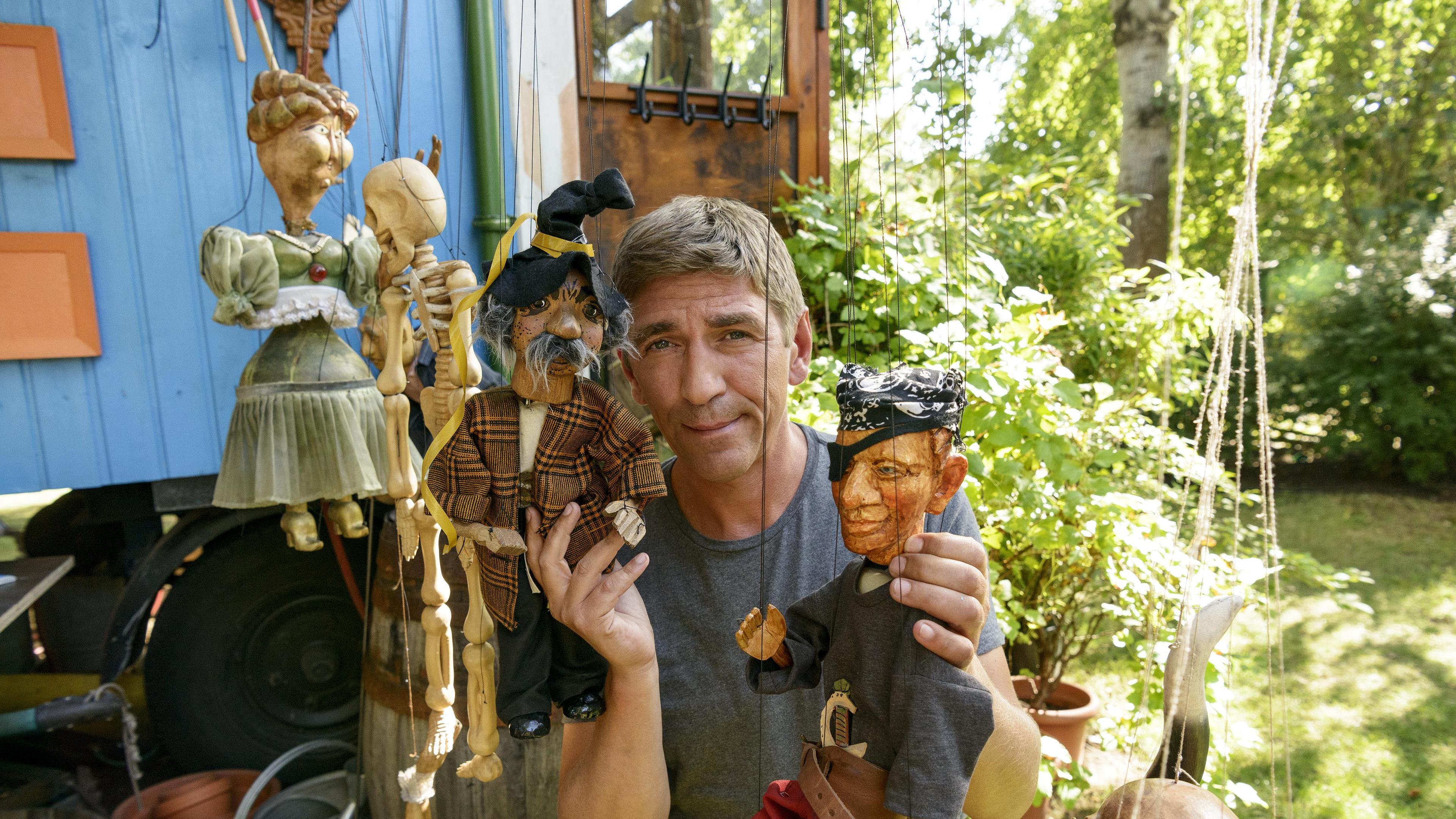 Fritz Fuchs hält eine Marionette in der Hand.