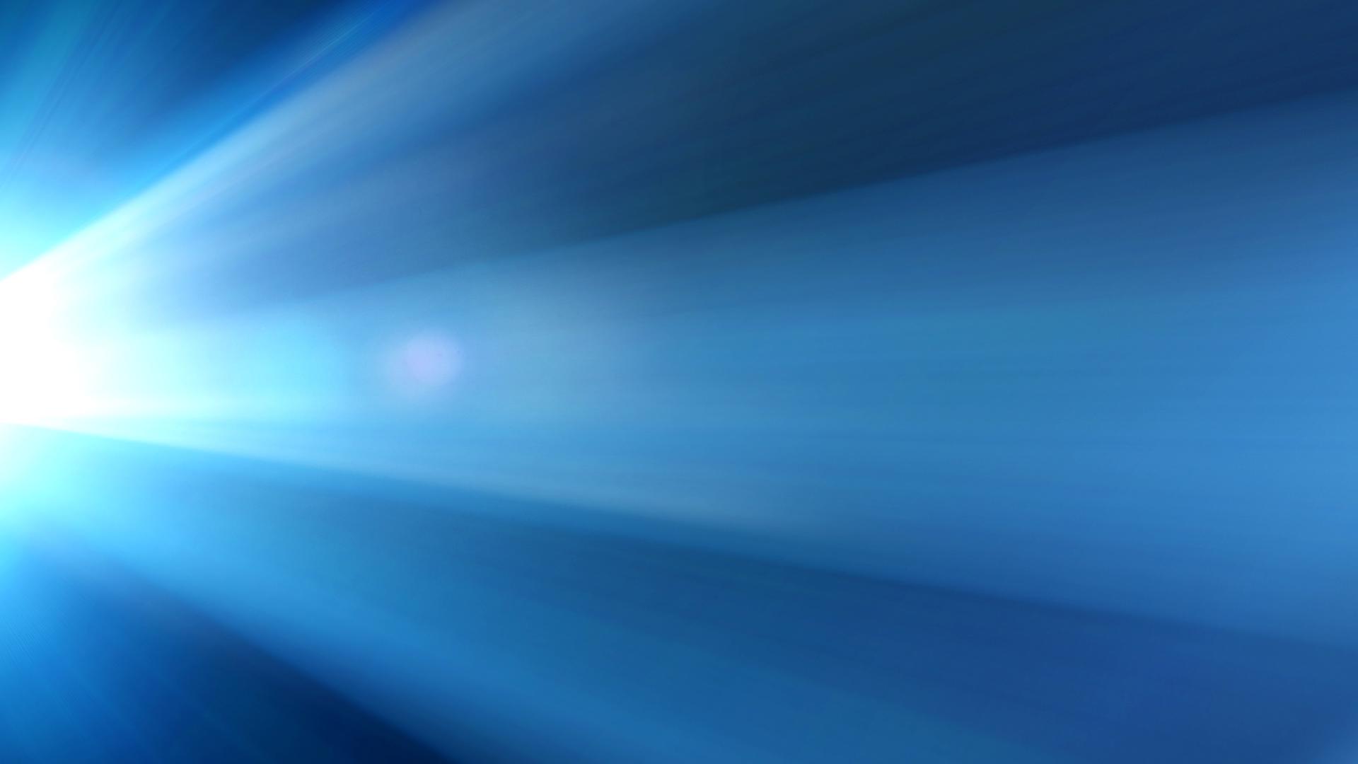 Abstraktes Bild: Weiße Lichstrahlen wie von einem Kinoprojektor vor blauem Hintergrund