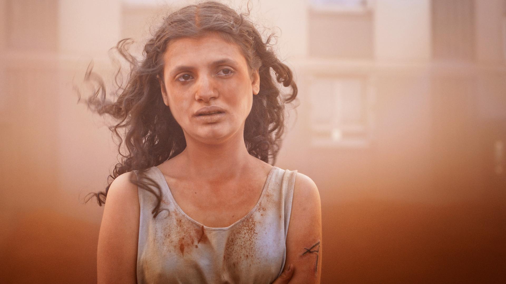 Man sieht eine Frau, die ein verschmutztes Oberteil trägt.