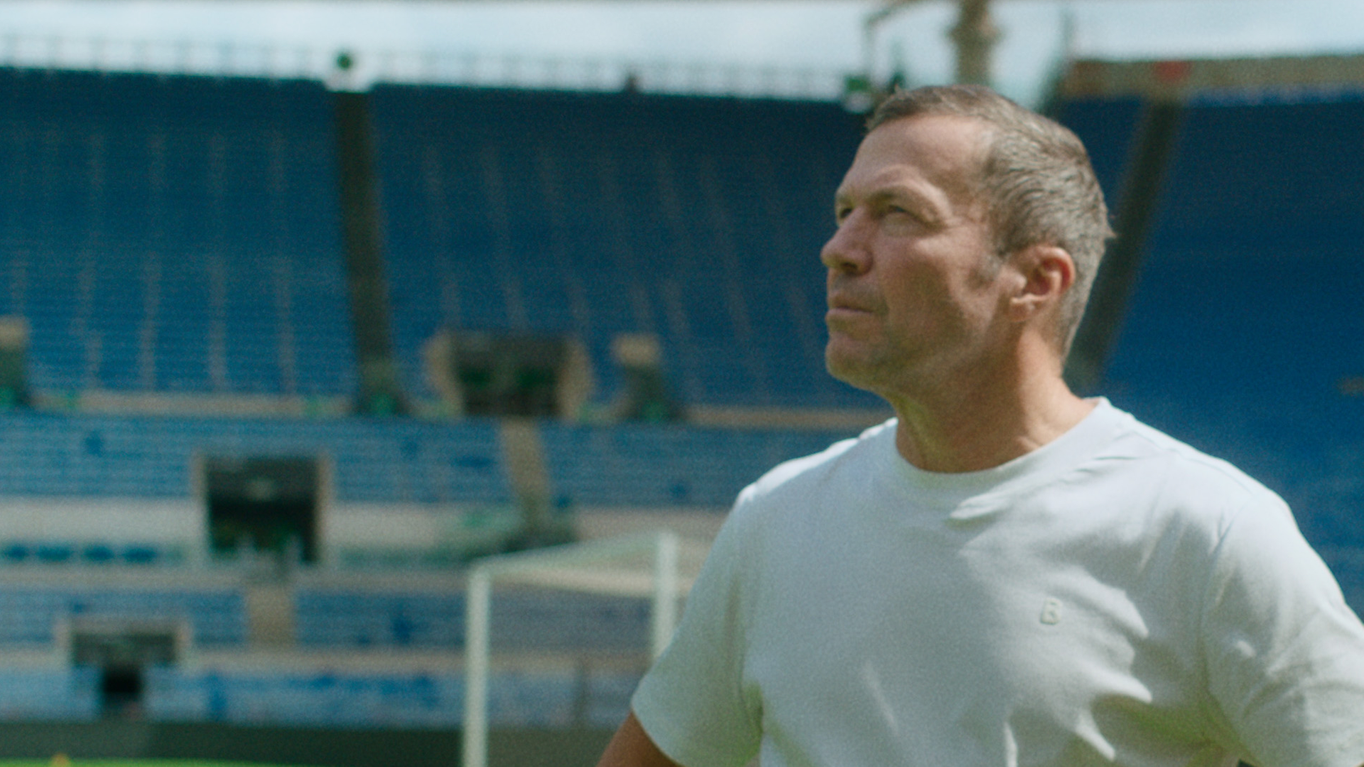 Ein Mann steht in einem Fußballstadion.