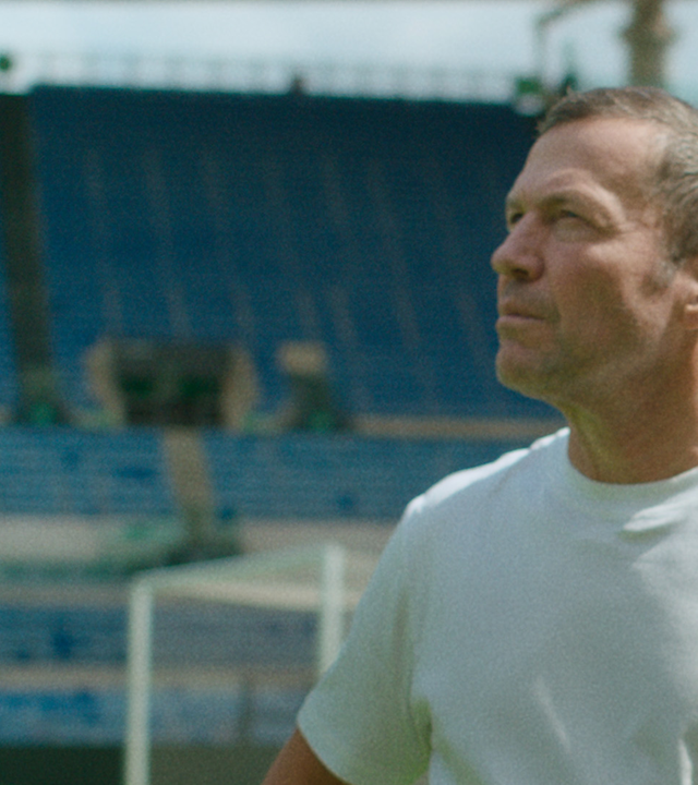 Ein Mann steht in einem Fußballstadion.