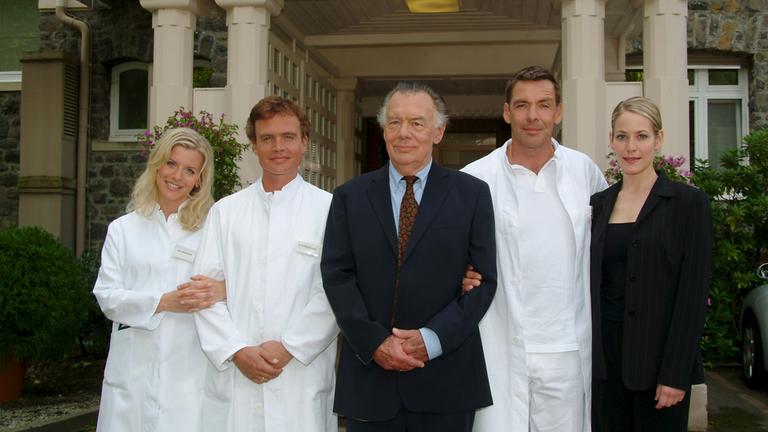 "Die Schwarzwaldklinik - Neue Zeiten": Eva Habermann, Alexander Wussow, Klausjürgen Wussow, Sascha Hehn, Stephanie Japp stehen vor der Schwarzwaldklinik. 