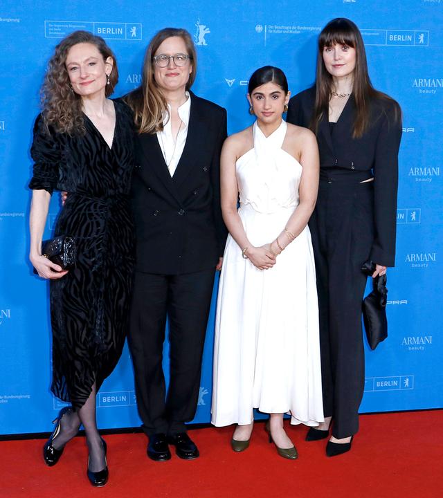 Vier Frauen stehen vor dem blauen Hintergrund der Berlinale-Pressekonferenz auf einem roten Teppich. Drei Frauen mittleren Alters tragen dunkle Anzüge und Kleider, eine jüngere Frau trägt ein schulterfreies weißes Kleid.