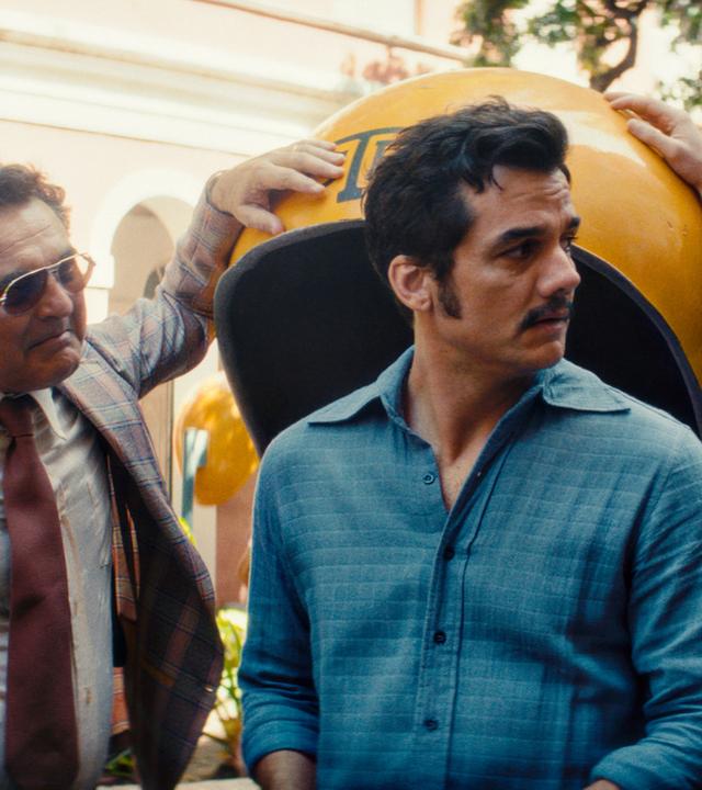 Vier Männer unterhalten sich auf einer Straße.