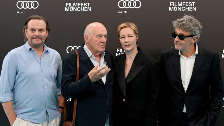 Die Darsteller Devid Striesow (l-r), Hanns Zischler, Sandra Hüller und Regisseur Pawel Pawlikowski stehen bei der offiziellen Eröffnung des 43. Filmfest München mit dem Film Vaterland in der Isarphilharmonie im HP8 auf dem Blauen Teppich.