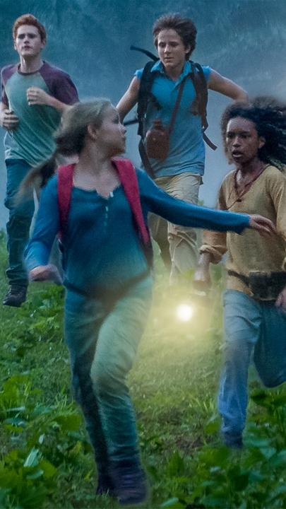 Die "Fünf Freunde" und ihre neue Freundin Joe (v.l.n.r.) rennen über eine Wiese: Joe (Davina Weber), Anne (Neele Marie Nickel), Julian (Quirin Oettl), Dick (Justus Schlingensiepen) und George (Valeria Eisenbart). Im Hintergrund ein Berg und davor Palmen.