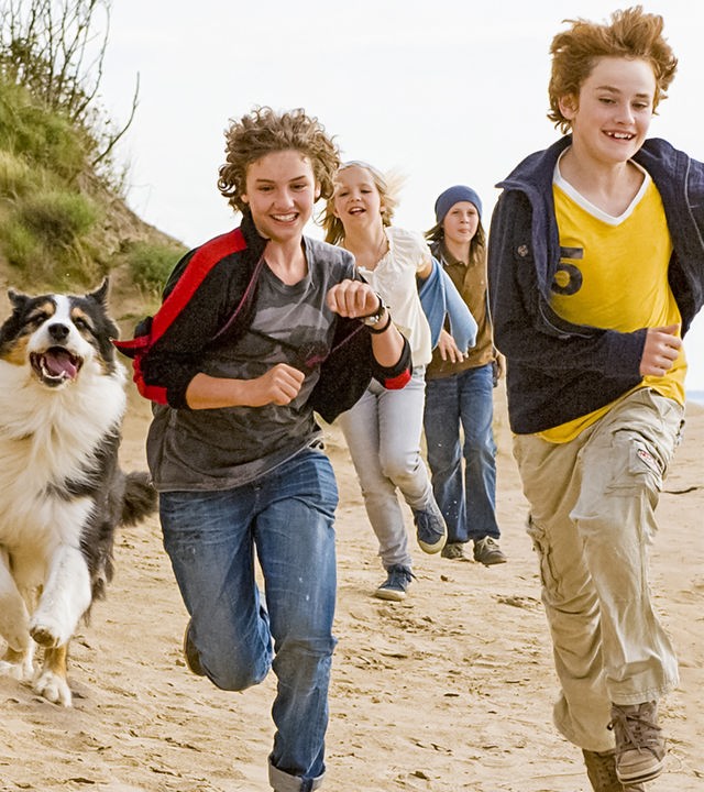 Von links nach rechts: Die fünf Freunde rennen am Strand: Hund Timmy, George (Valeria Eisenbart), Anne (Neele Marie Nickel), Dick (Justus Schlingensiepen) und Julian (Quirin Oettl)