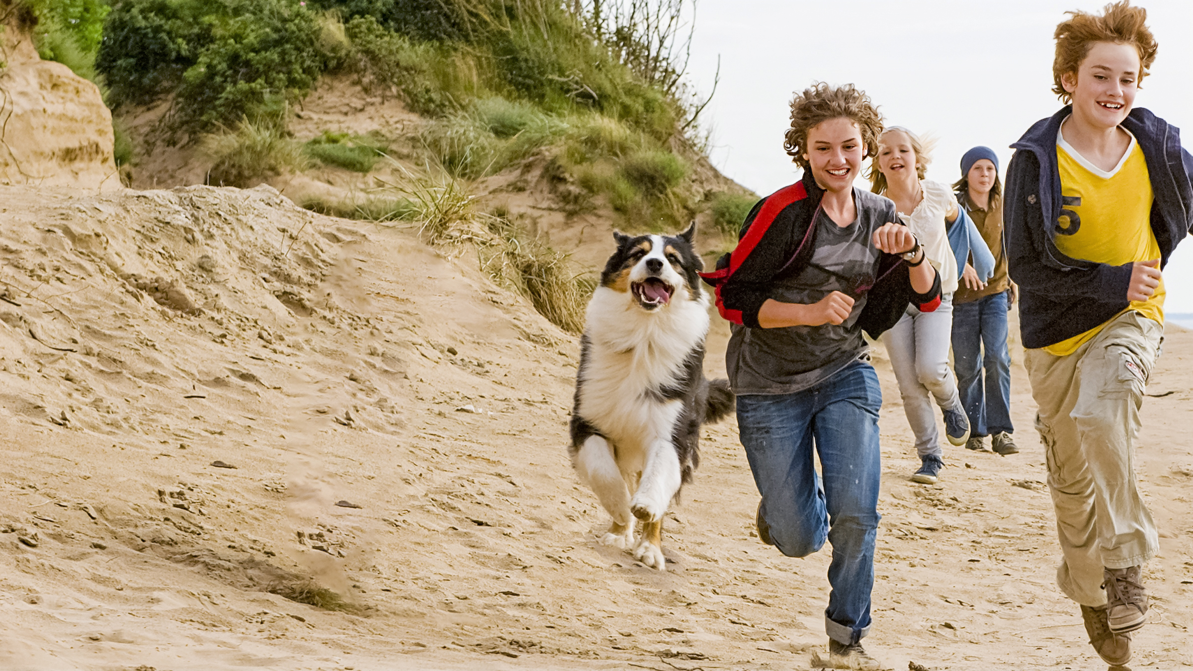 Von links nach rechts: Die fünf Freunde rennen am Strand: Hund Timmy, George (Valeria Eisenbart), Anne (Neele Marie Nickel), Dick (Justus Schlingensiepen) und Julian (Quirin Oettl)