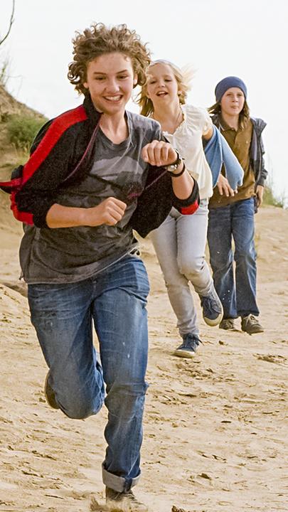 Von links nach rechts: Die fünf Freunde rennen am Strand: Hund Timmy, George (Valeria Eisenbart), Anne (Neele Marie Nickel), Dick (Justus Schlingensiepen) und Julian (Quirin Oettl)