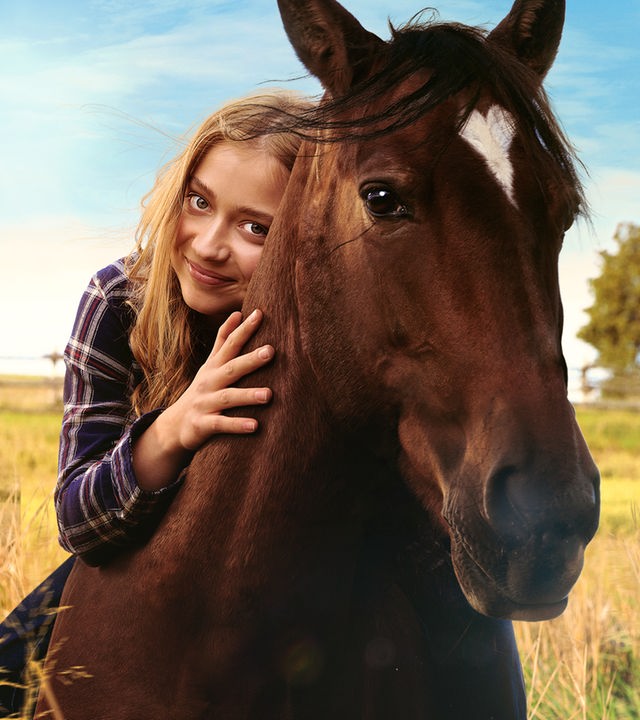"Ponyherz - Wild und frei": Anni sitzt auf dem Pferd Ponyherz und hat den Kopf des Pferdes eng umschlungen. 
