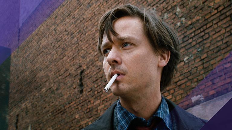 Großaufnahme von Tom Schilling mit Zigarette im Mund.