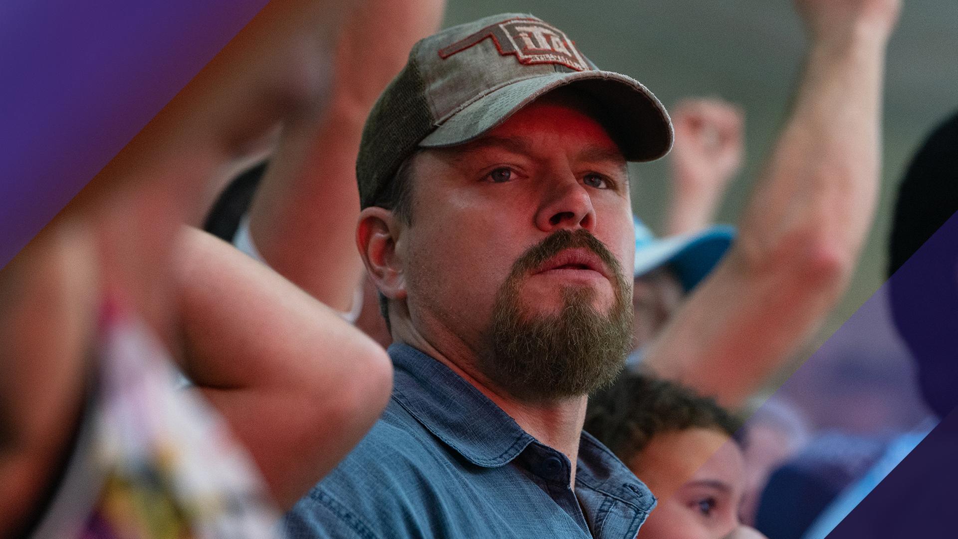 Großaufnahme von Matt Damon, der mit Baseballkappe in einer Menschenmenge steht.