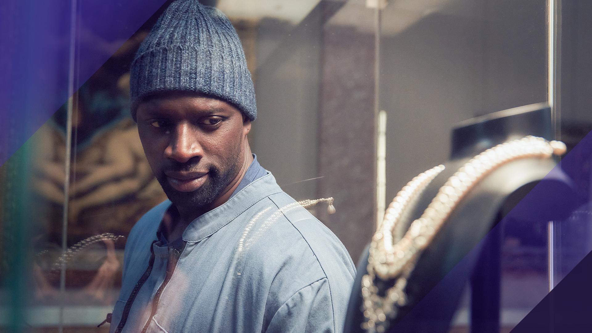 Assane Diop (Omar Sy) schaut in eine Vitrine, in der ein Collier auf einer Büste ausgestellt ist.