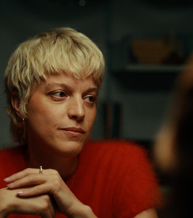 Frau mit kurzen hellen Haaren schaut auf 