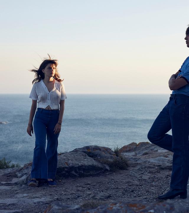 Frau und Mann stehen sich gegenüber am Meer