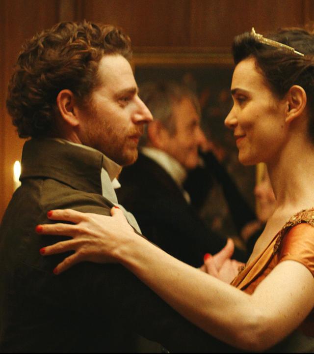 Zu sehen sind ein Mann und eine Frau, die miteinander tanzen und sich dabei tief in die Augen schauen.