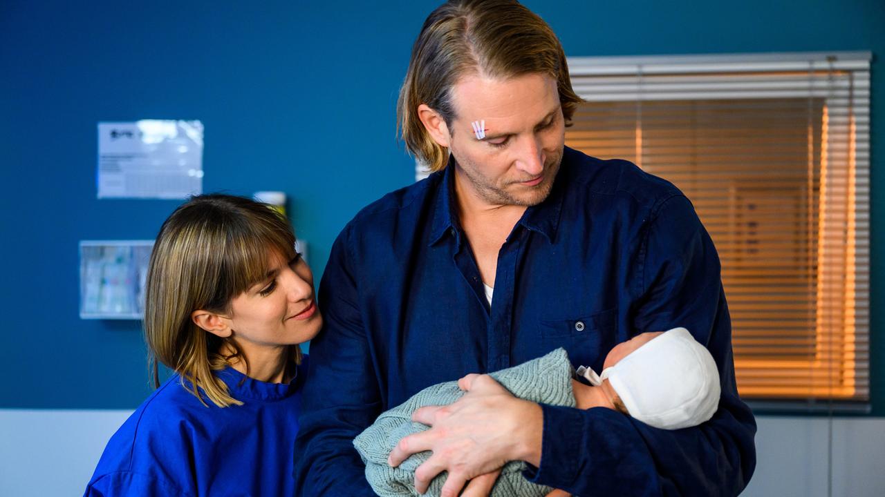 "Bettys Diagnose - Findelkind": Lukas Hilpert (Niklas Löffler) und Rike Köhler (Isabell Horn) stehen mit Betty Weiss (Annina Hellenthal) in der Schwesternkanzel. Alle schauen auf den gelben Notizzettel, den Betty in der rechten Hand hält.