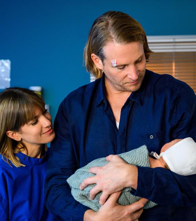 "Bettys Diagnose - Findelkind": Lukas Hilpert (Niklas Löffler) und Rike Köhler (Isabell Horn) stehen mit Betty Weiss (Annina Hellenthal) in der Schwesternkanzel. Alle schauen auf den gelben Notizzettel, den Betty in der rechten Hand hält.