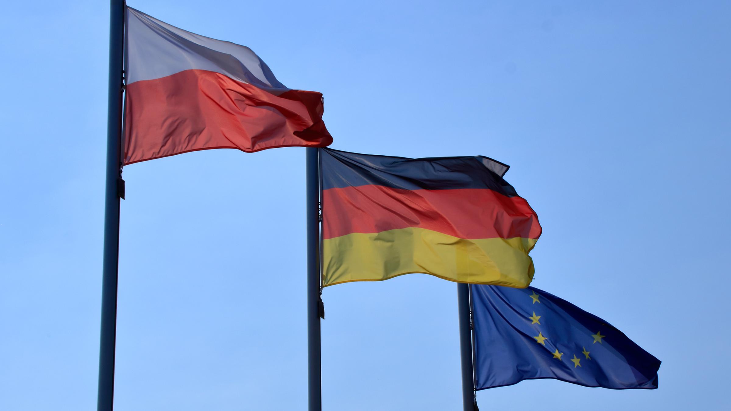 Flaggen wehen vor einem blauen Himmel im Wind.