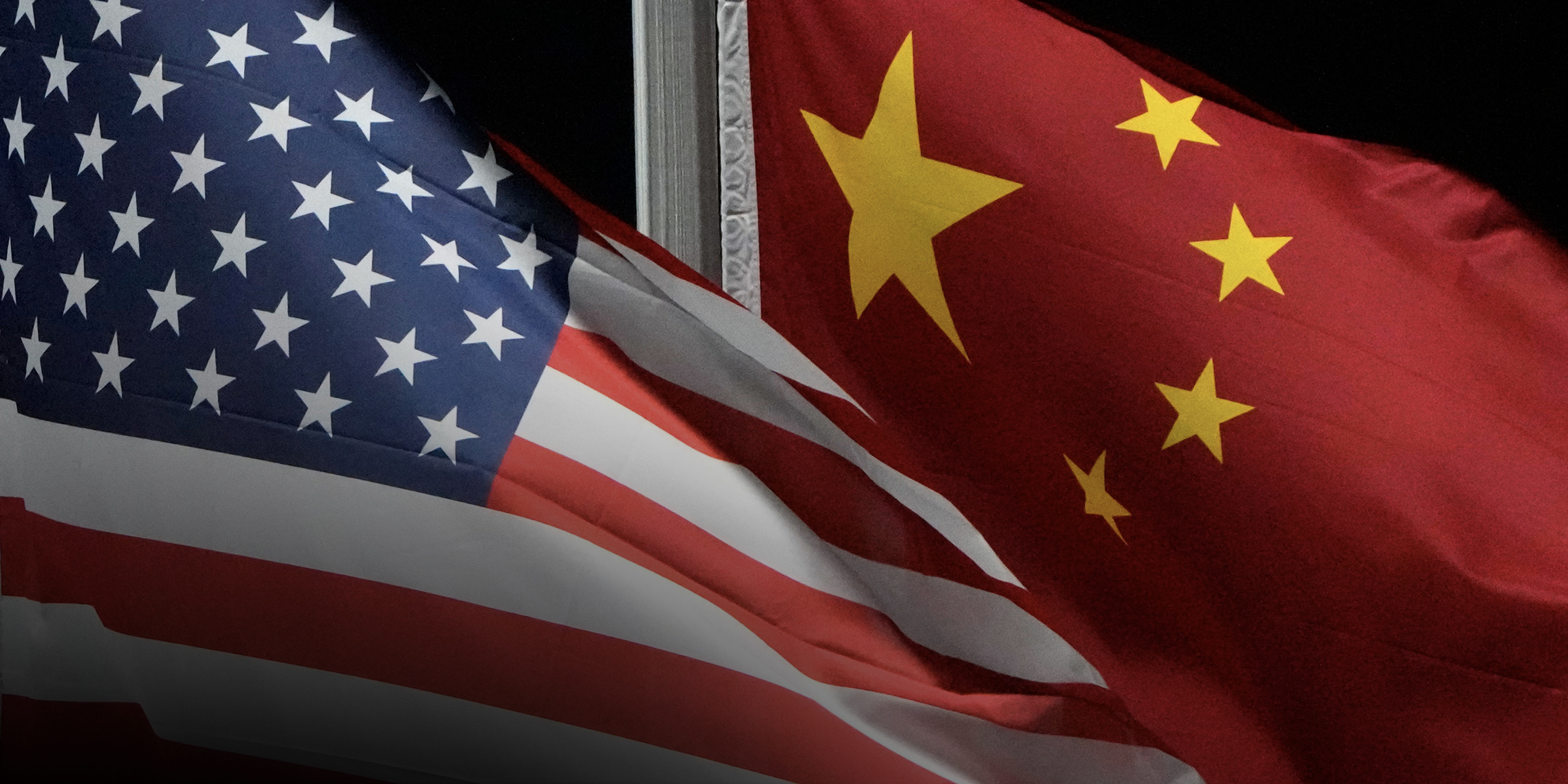 Eine US-amerikanische und eine chinesische Fahne wehen im Wind