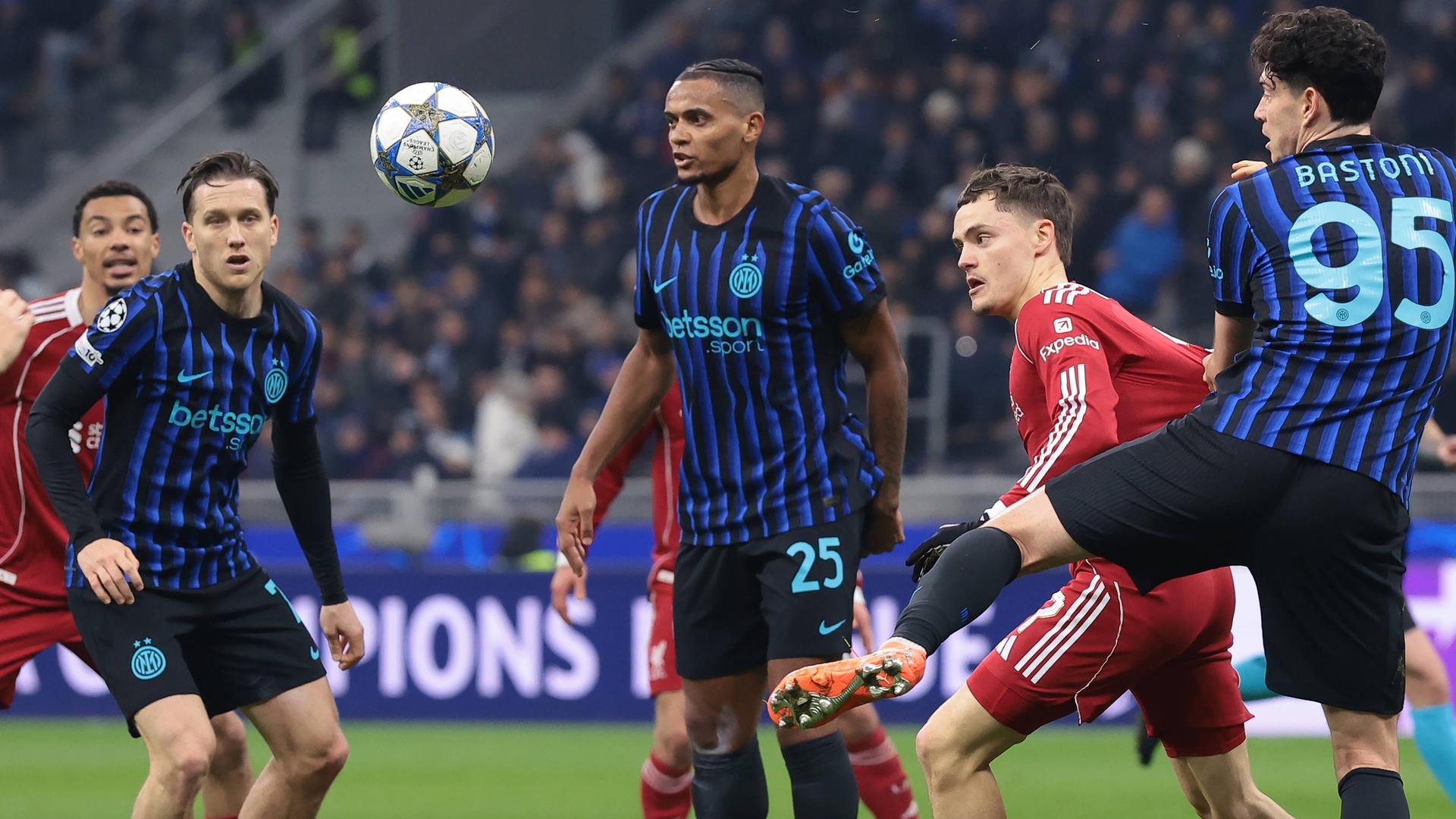 Im Zweikampf wird Liverpools Stürmer Florian Wirtz von Inter Mailands Verteidiger Alessandro Bastoni am Trikot gezogen und bei der Ballmitnahme gestört.