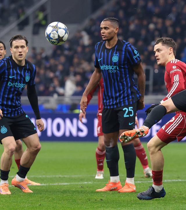 Im Zweikampf wird Liverpools Stürmer Florian Wirtz von Inter Mailands Verteidiger Alessandro Bastoni am Trikot gezogen und bei der Ballmitnahme gestört.