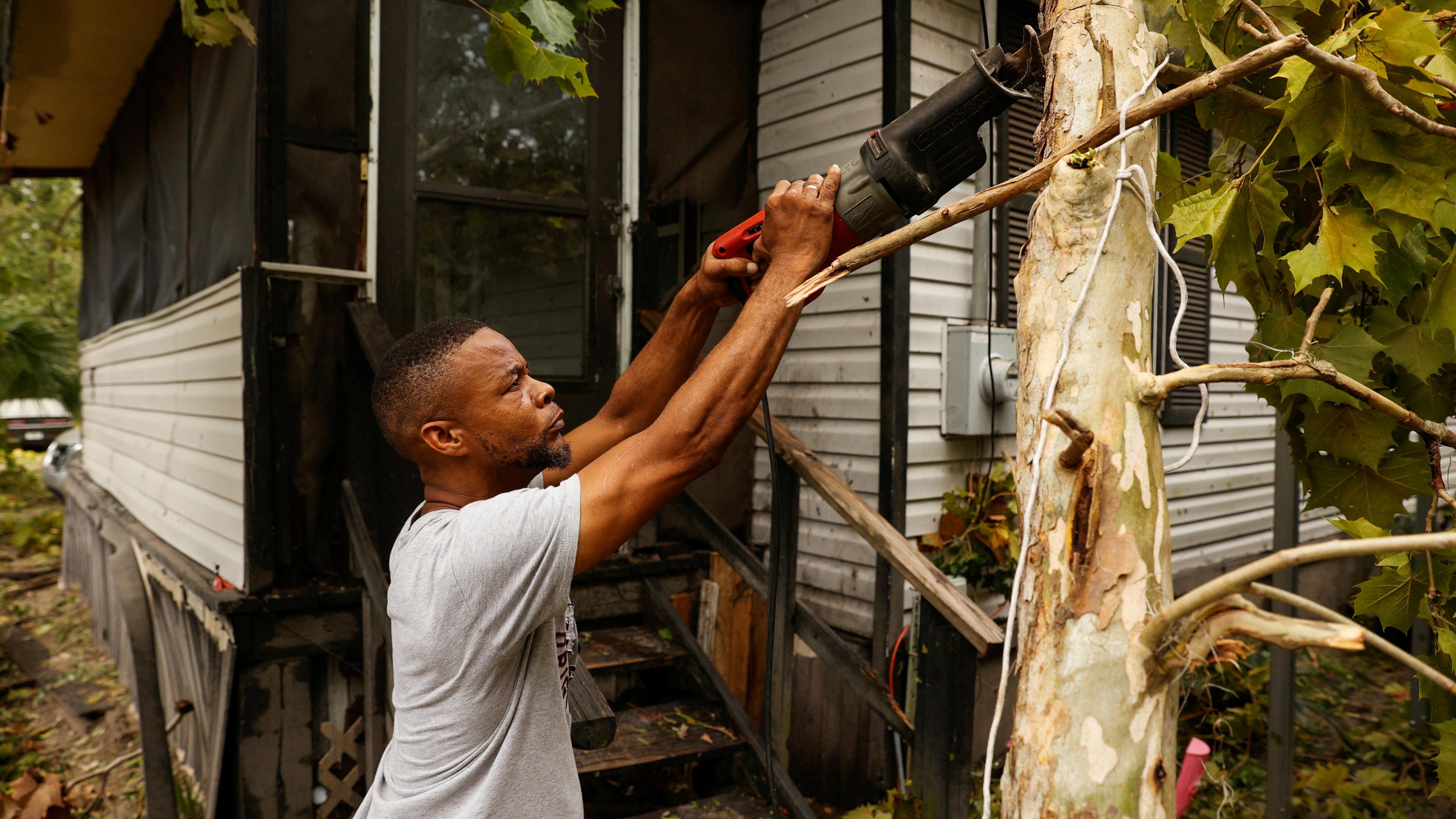Hurrikan "Idalia" hat in Florida gewütet: Ein Mann zersägt einen Baum, der auf seine Haus gefallen ist.