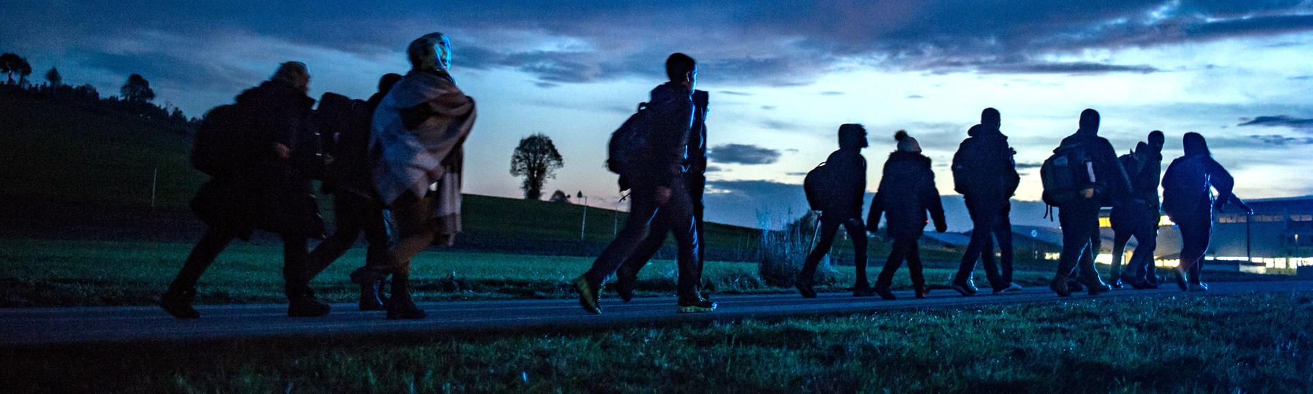 Archiv: Flüchtlinge gehen am 28.10.2015 hinter der deutsch-österreichischen Grenze in Wegscheid (Bayern) zu einer Notunterkunft