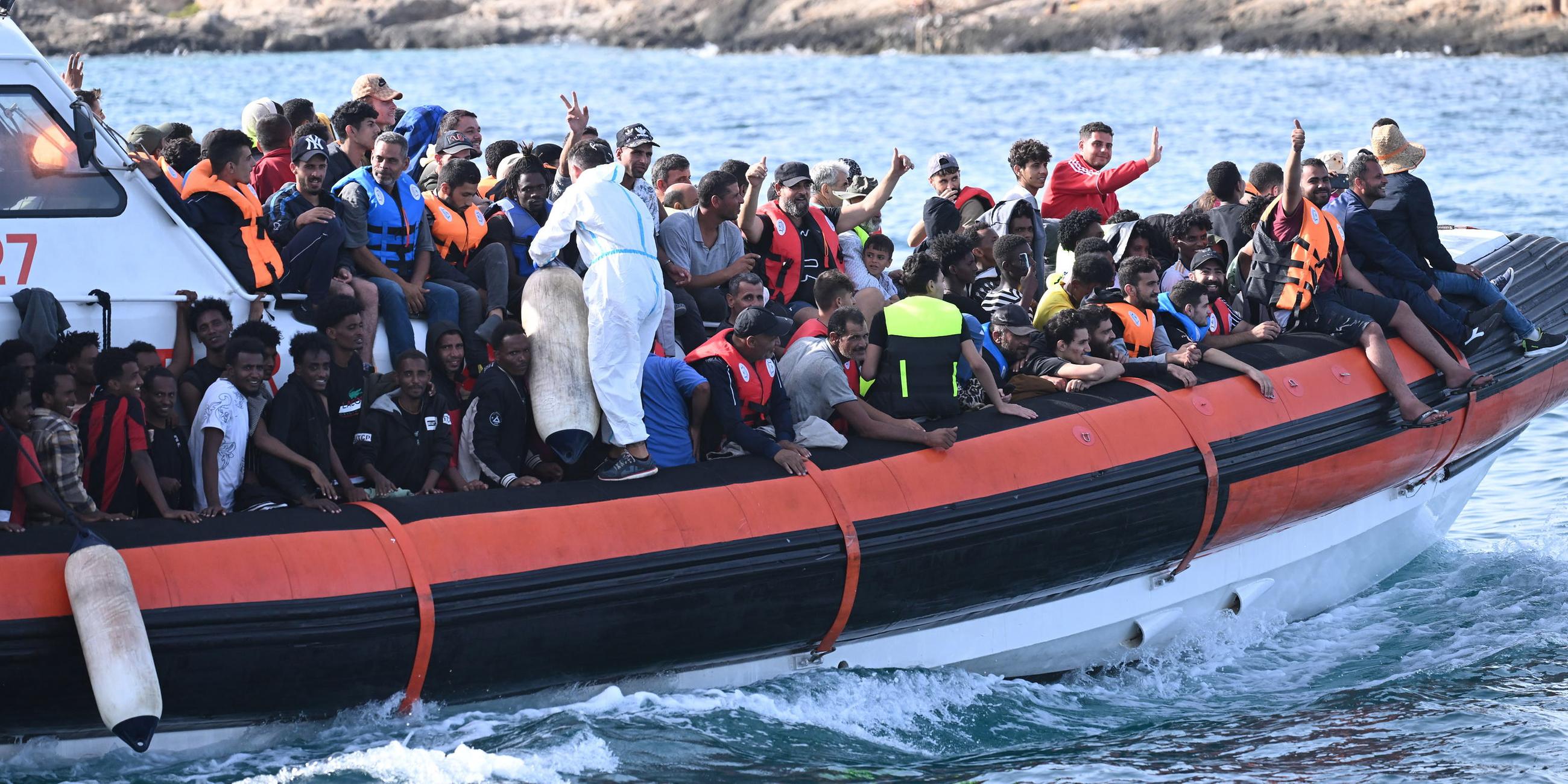 Migranten drängen sich an Deck des Patrouillenboots CP327 der italienischen Küstenwache, als es im Hafen von Lampedusa (Italien) einläuft, aufgenommen am 18.09.2023