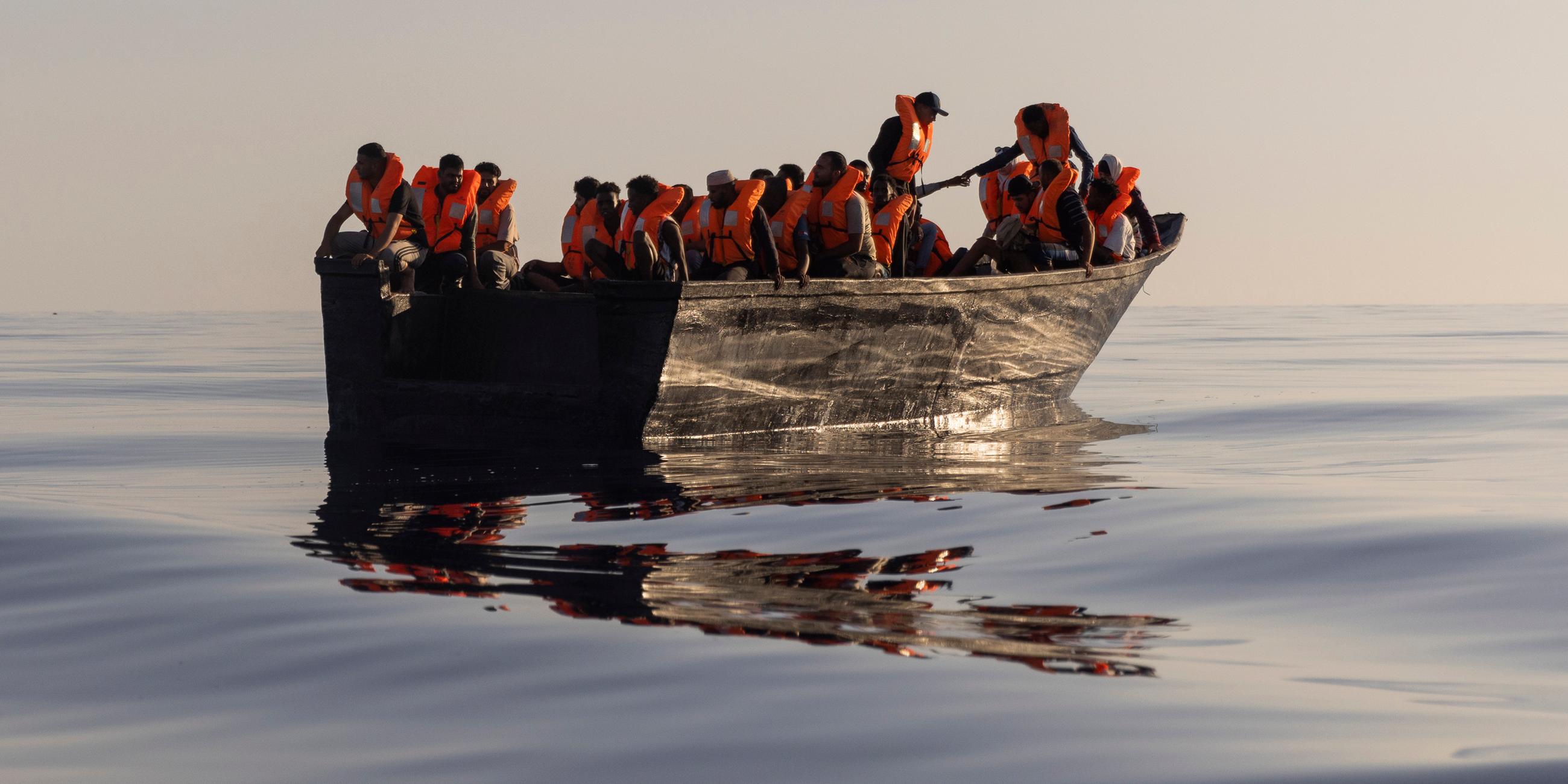 Ein Holzboot voller Menschen auf dem Mittelmeer