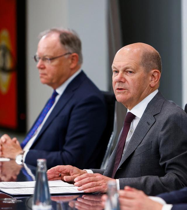 Zu sehen ist Bundeskanzler Olaf Scholz, flankiert von Stephan Weil, Vorsitzender der Ministerpräsidentenkonferenz, sowie Henrik Wüst, Ministerpräsident von NRW.