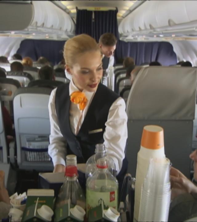 Fluggastrechte: Stewardess im Flugzeug bedient