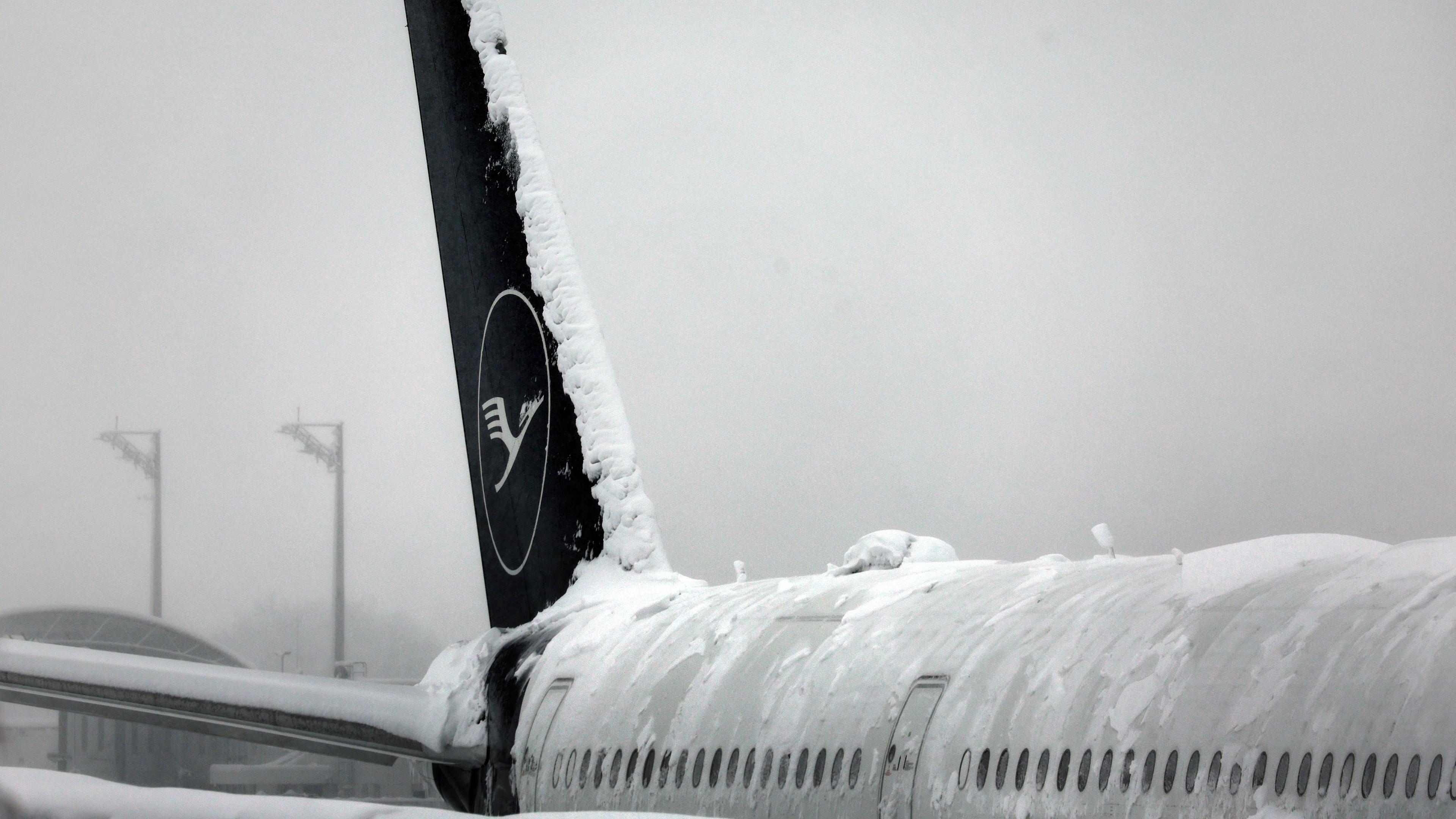  Eine Maschine der Lufthansa steht auf dem verschneiten Flughafen in München am 02.12.2023.