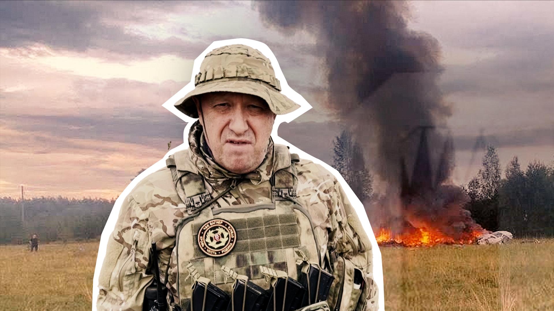 Jewgeni Prigoschin in Militärkleidung mittig im Vorergrund. Im Hintergrund der Ort des Absturzorts?