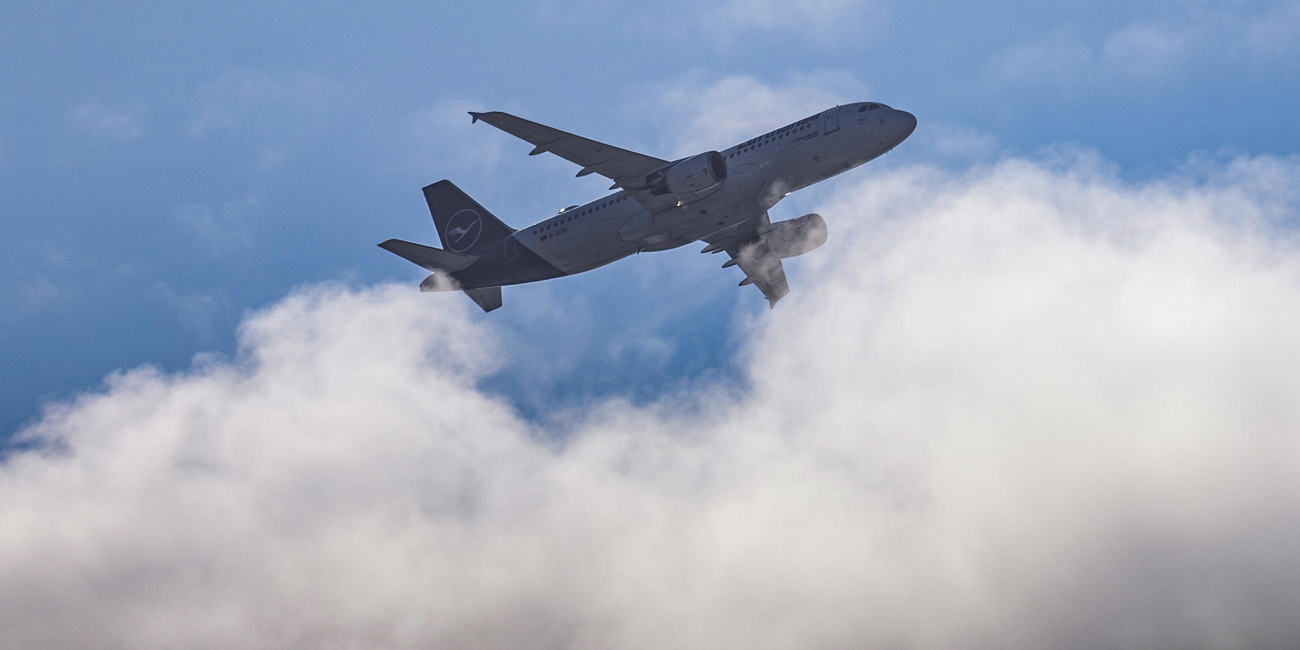 Ein Flugzeug vom Typ Airbus A320-214 der Lufthansa fliegt über den Wolken am Himmel über Dresden.