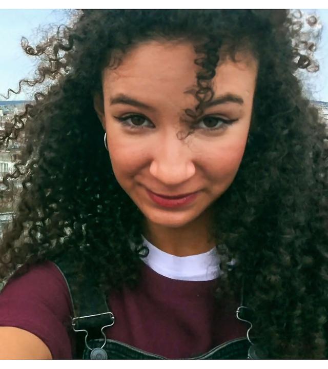 Lena steht neben Ines und schaut sie an. Sie stehen beide auf einem Dach und schauen in die Kamera.